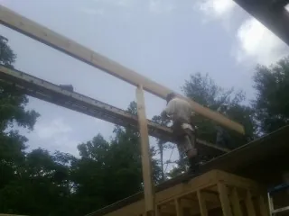 Carpenter setting a ridge beam over a new addition frame — Ice Dam Removal by Roofing Brothers in Stevenson Ranch