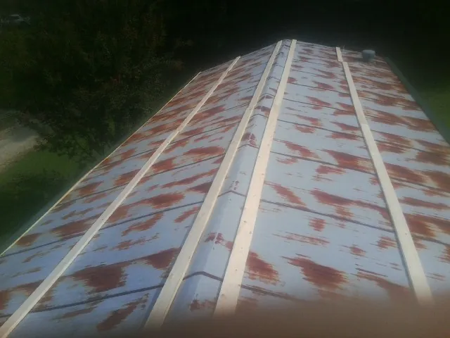 Rusted metal roof panels with new wood purlins before replacement — Storm Damage Roof Repair in Stevenson Ranch by Roofing Brothers
