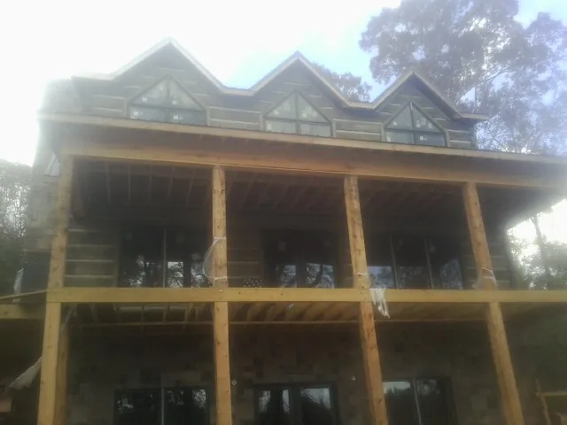 Dormers and porch framing on a large log home under construction — Roof Coating work by our crew in Stevenson Ranch