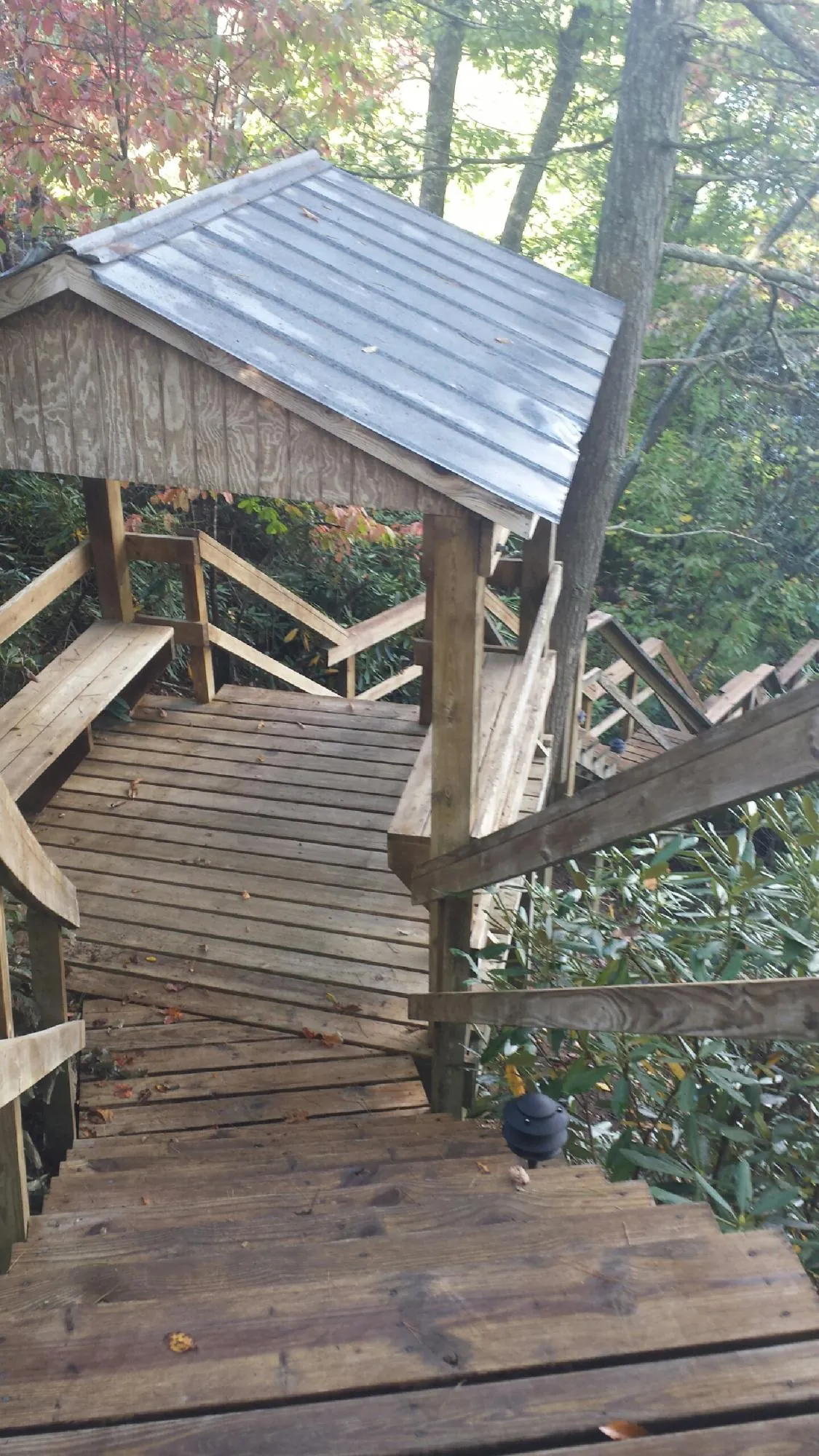 Metal roofed shelter over wooden steps on a wooded walkway — Skylight Repair & Installation work by our crew in Stevenson Ranch